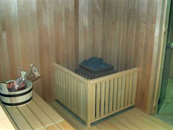 Kahoy na bakod para sa isang kalan sa sauna