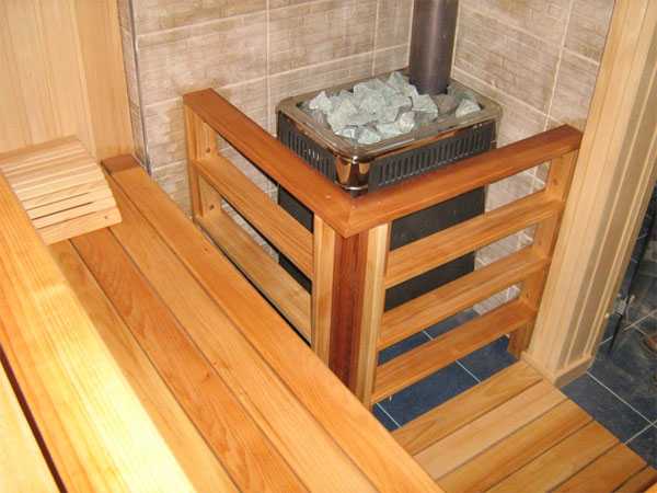 Kahoy na bakod para sa isang kalan sa sauna