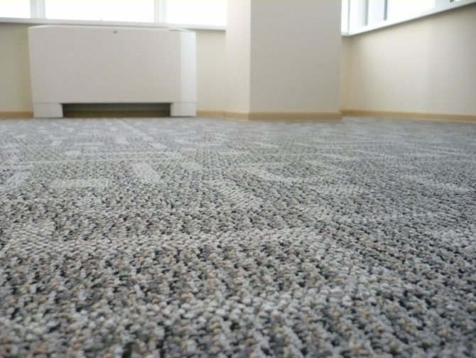 Doe-het-zelf warme vloer onder tapijt op een houten vloer